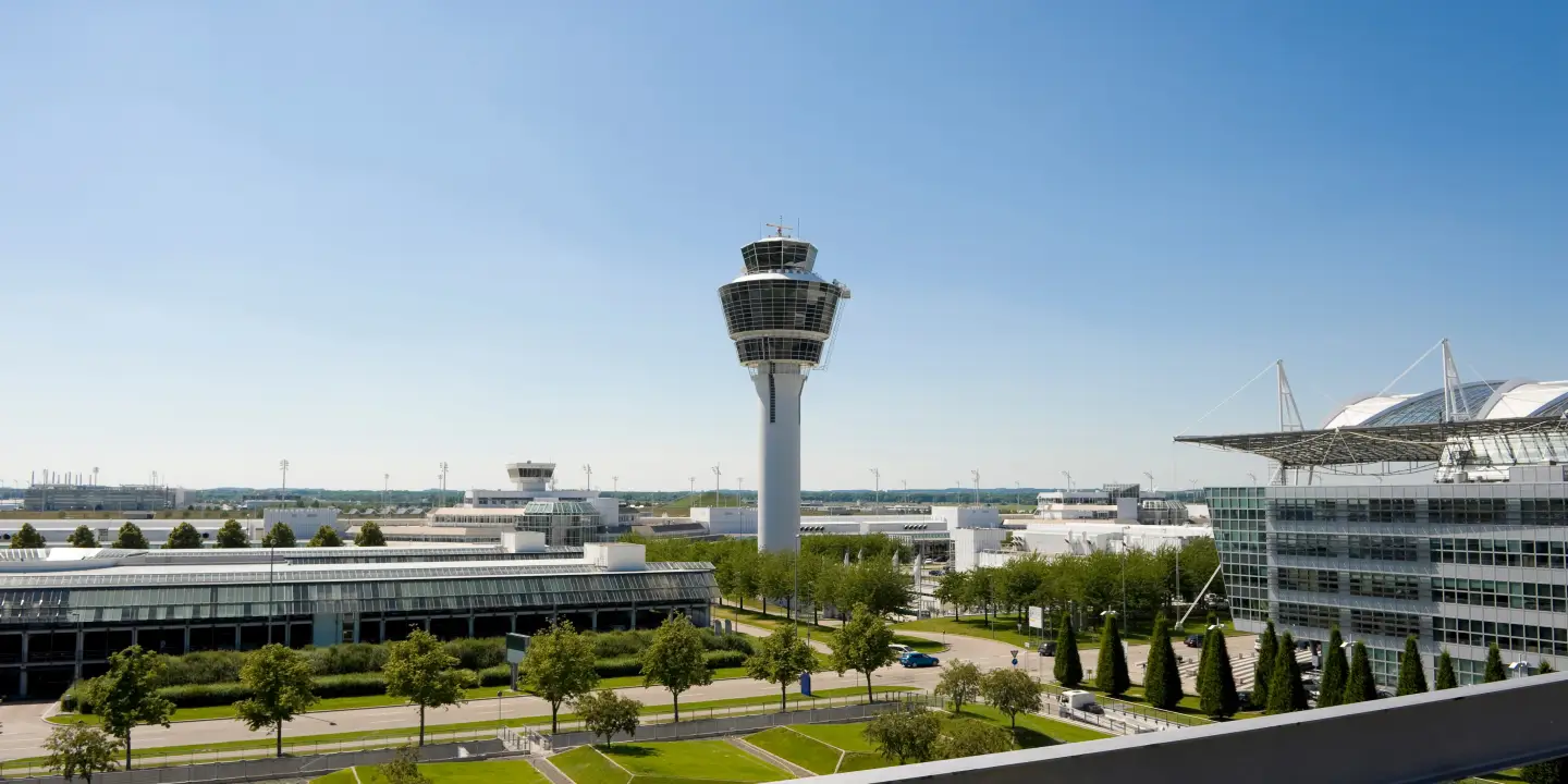 Blick auf den Flughafen München mit Tower, Terminalgebäuden und dem Munich Airport Center.