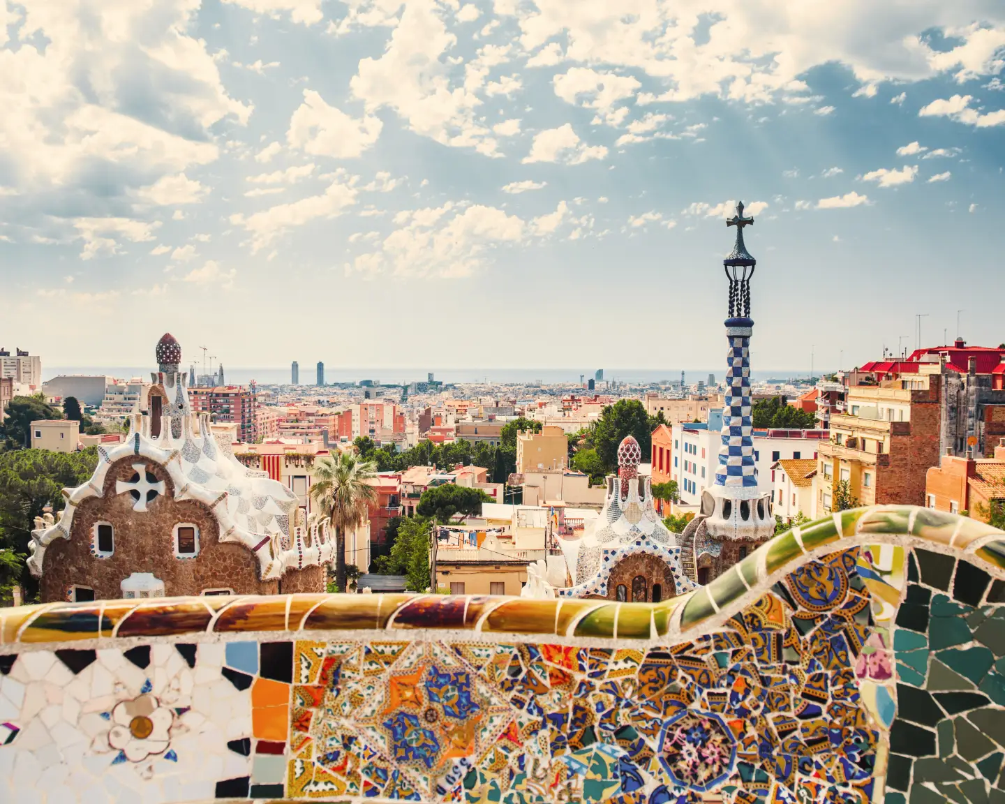 Des mosaïques colorées de Gaudí encadrent la vue depuis le parc Güell sur Barcelone et le quartier historique d'El Born.