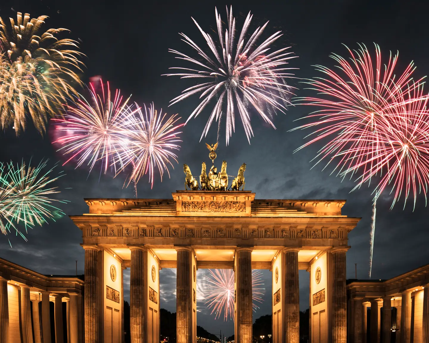 Feuerwerk über dem beleuchteten Brandenburger Tor in Berlin an Silvester.