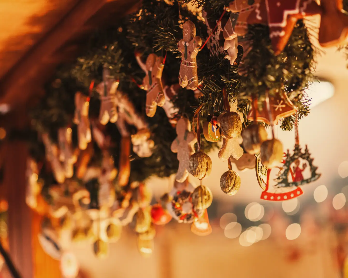 Festive Christmas decorations with gingerbread figures and Christmas ornaments at an illuminated Christmas market stall.