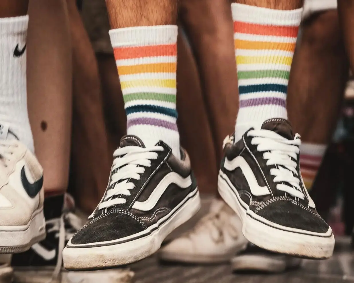 Menschen tragen Sneaker und Regenbogen-Socken während einer Pride-Veranstaltung als Zeichen für Vielfalt, Gleichberechtigung und die LGBTIQ+-Community.