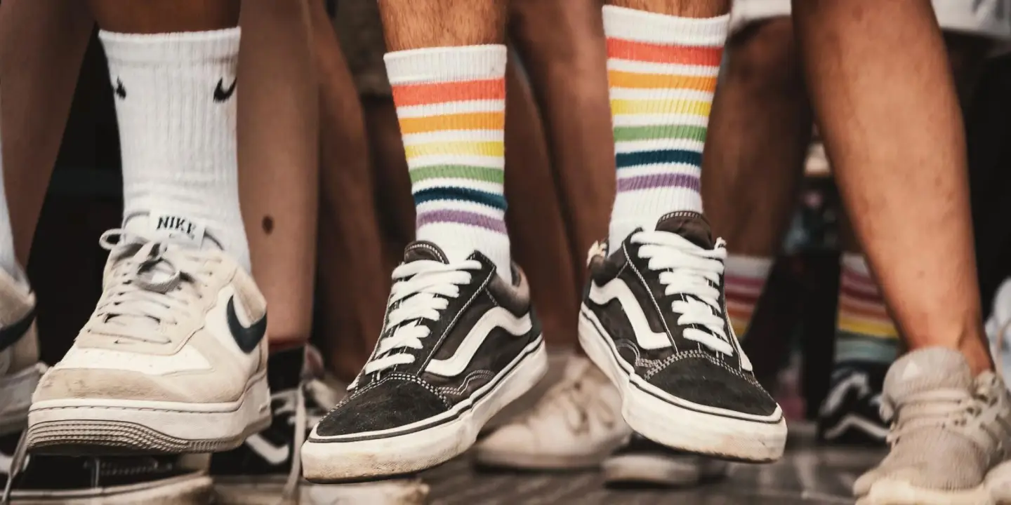Menschen tragen Sneaker und Regenbogen-Socken während einer Pride-Veranstaltung als Zeichen für Vielfalt, Gleichberechtigung und die LGBTIQ+-Community.