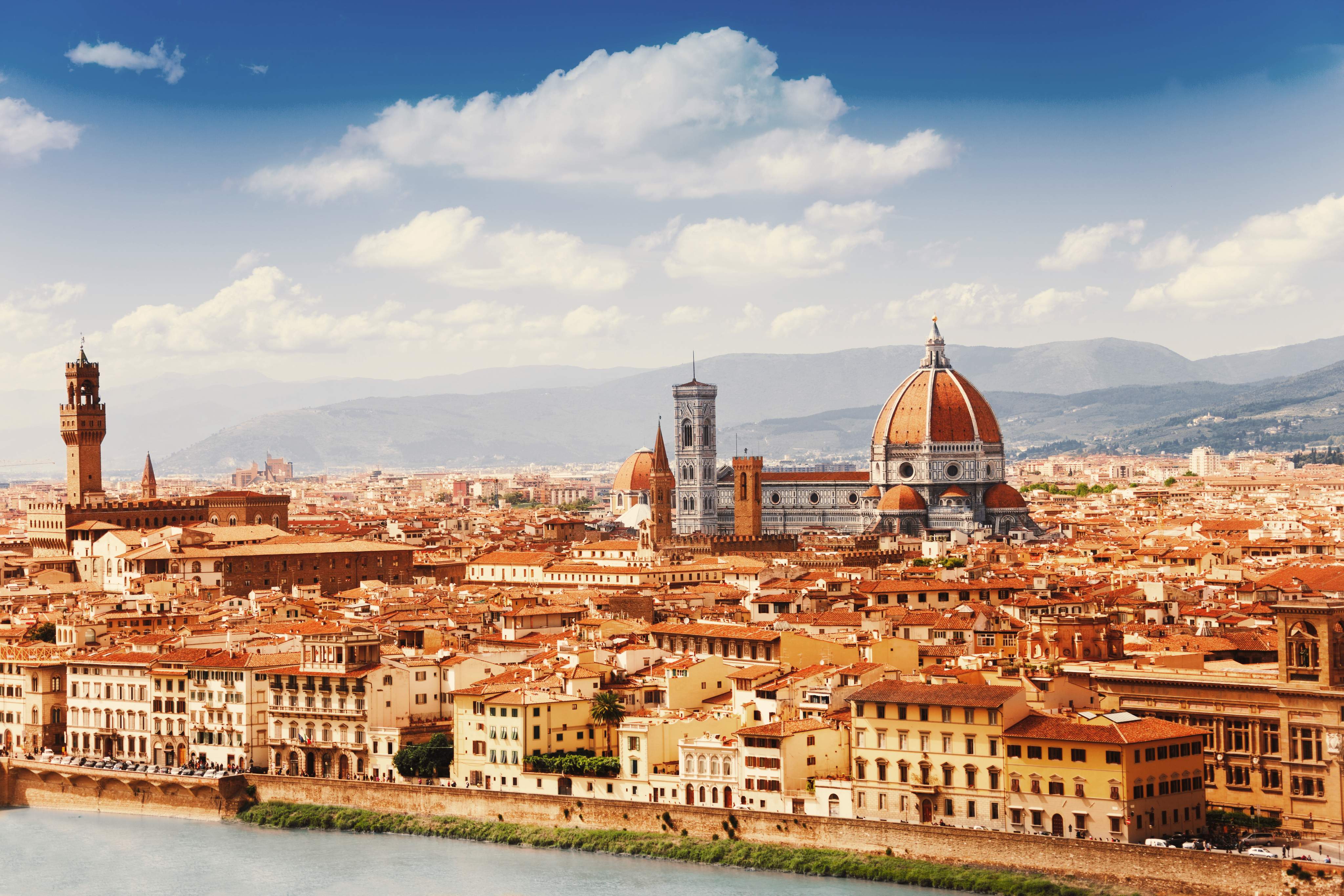 Panoramic view of Florence’s skyline with the Cathedral of Santa Maria del Fiore, historic buildings and the hills of Tuscany in the background.