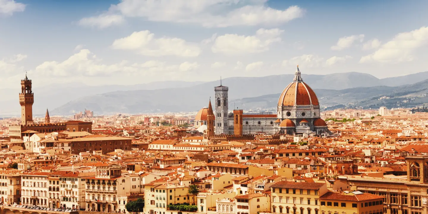 Panoramablick auf die Skyline von Florenz mit dem Dom Santa Maria del Fiore, historischen Gebäuden und den Hügeln der Toskana im Hintergrund.