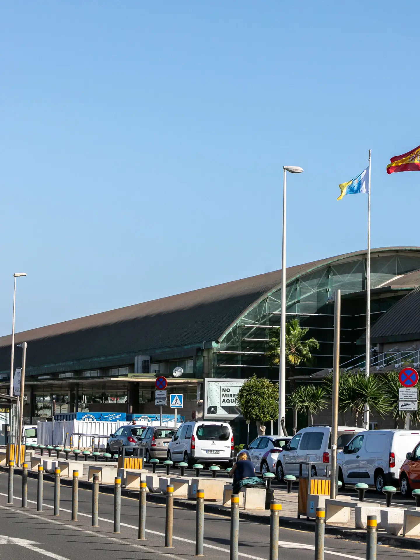 Außenansicht des Terminals am Flughafen Fuerteventura mit spanischer und europäischer Flagge.