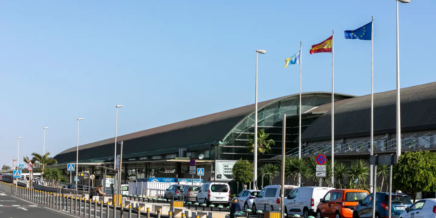 Außenansicht des Terminals am Flughafen Fuerteventura mit spanischer und europäischer Flagge.