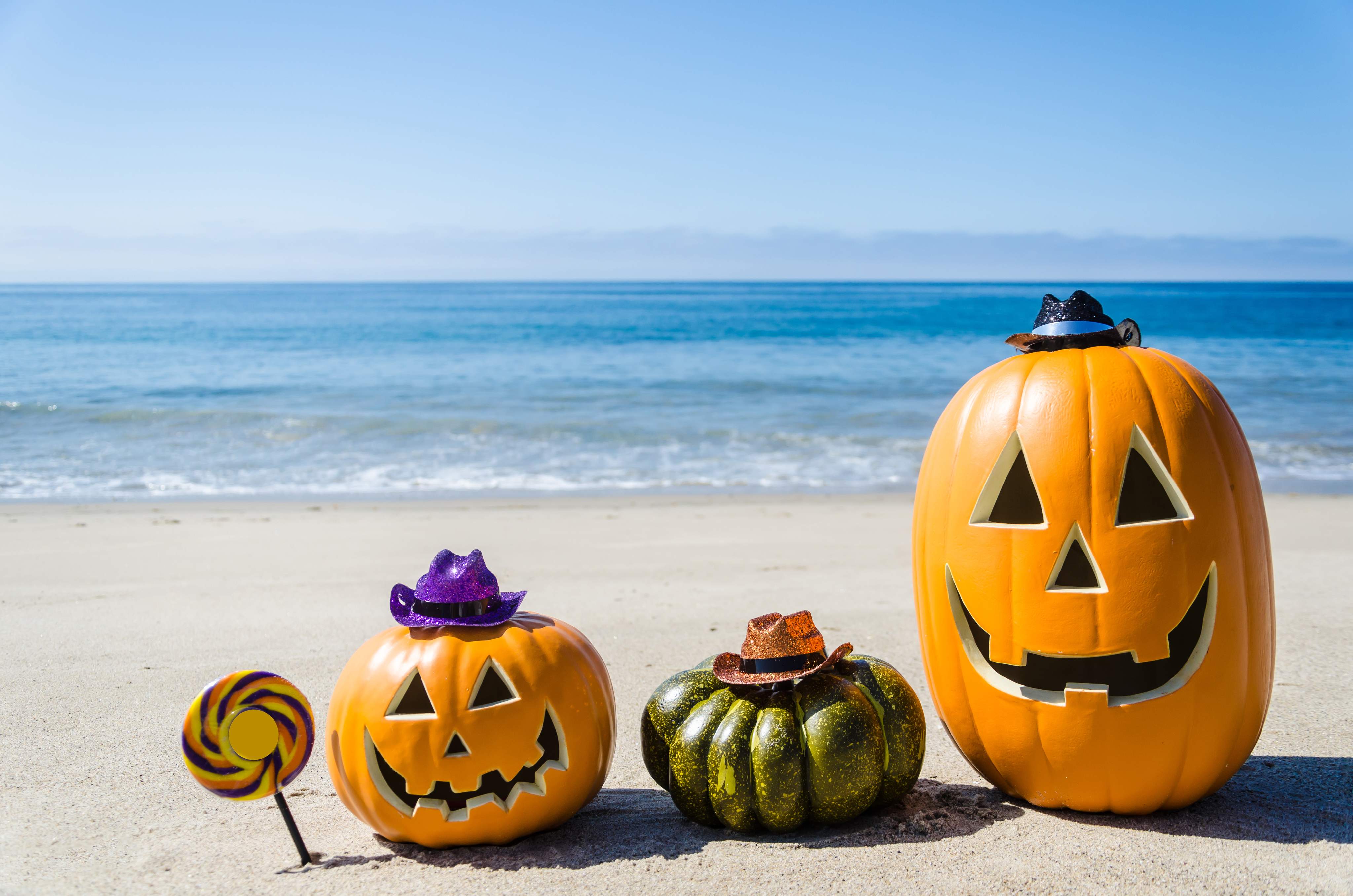 Ocean Happy Halloween background with three pumpkins and candy