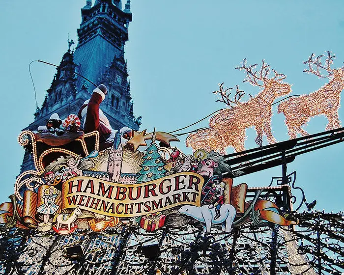 Festively illuminated decoration of the Hamburg Christmas market with Santa Claus in a sleigh and reindeer in front of Hamburg City Hall.