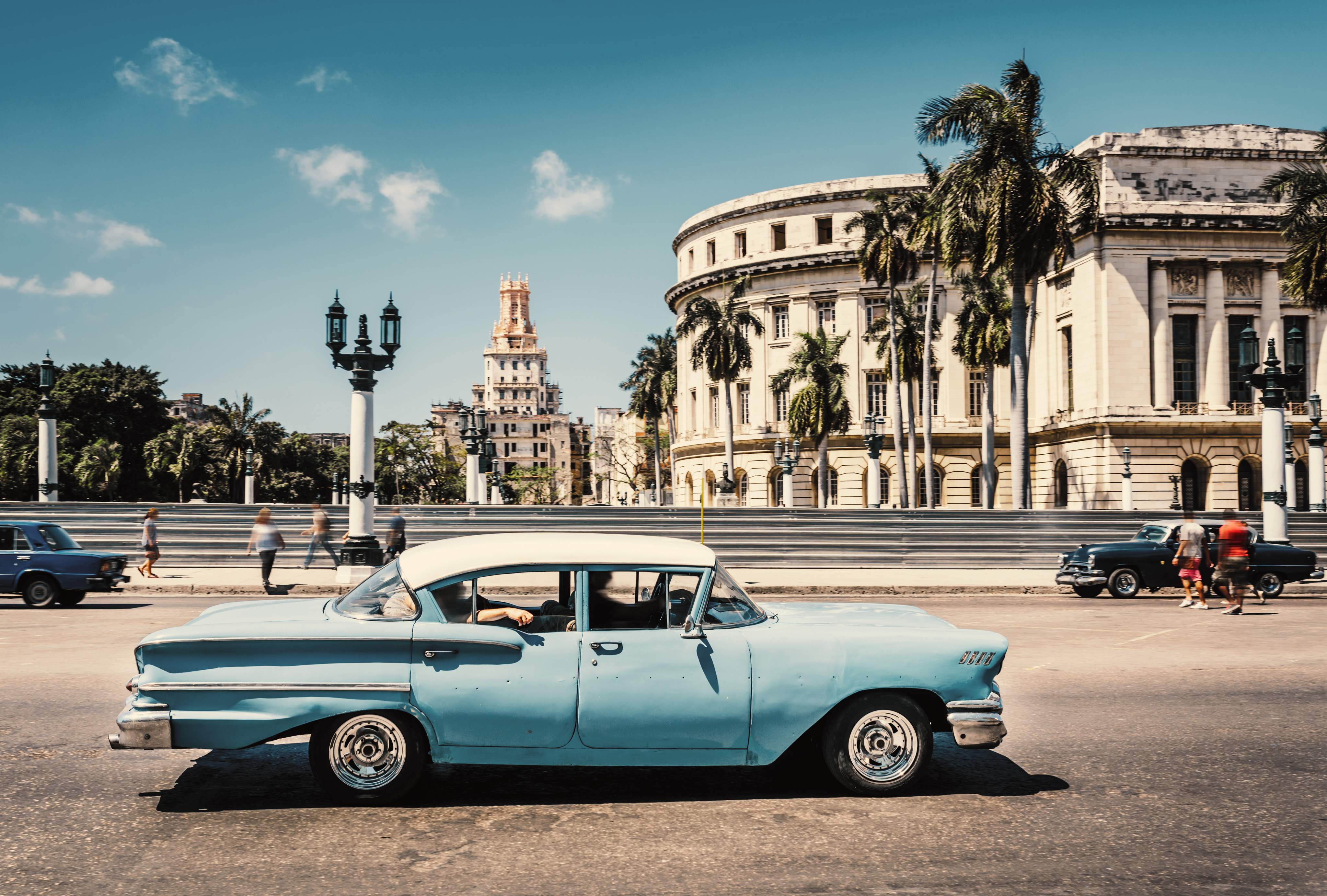 Old American car driving at a street of old Havana, Cuba