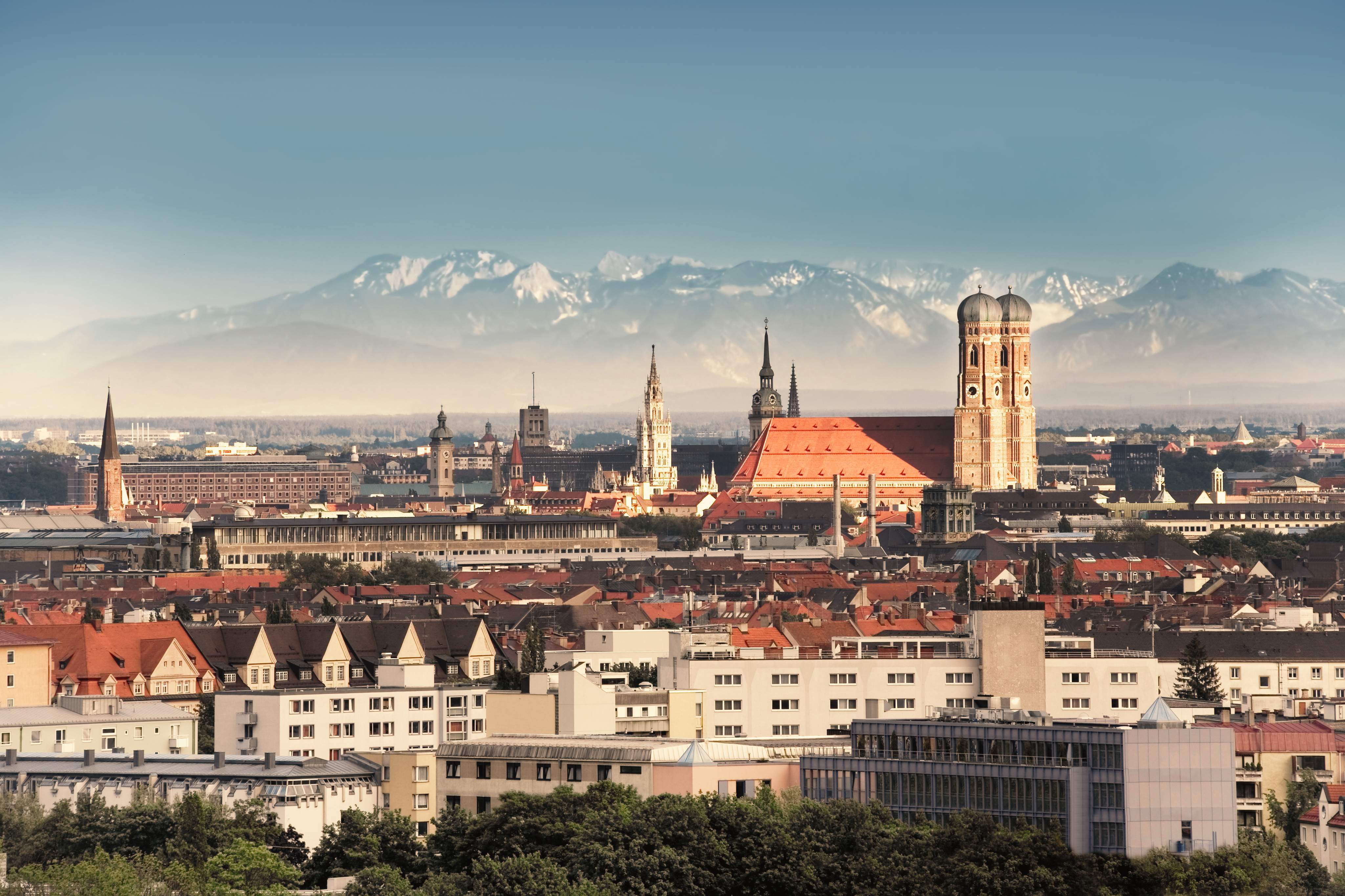 Munich, capital city of Germany's Free State of Bavaria. CIty skyline in the evening light. The Alps visible in the background.