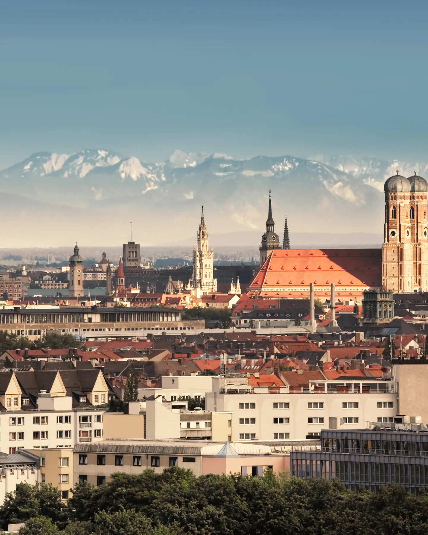 Munich, capital city of Germany's Free State of Bavaria. CIty skyline in the evening light. The Alps visible in the background.