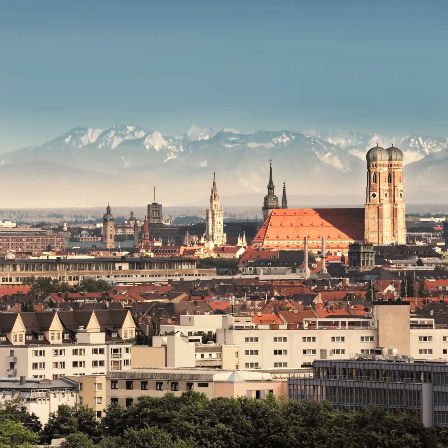 Munich, capital city of Germany's Free State of Bavaria. CIty skyline in the evening light. The Alps visible in the background.