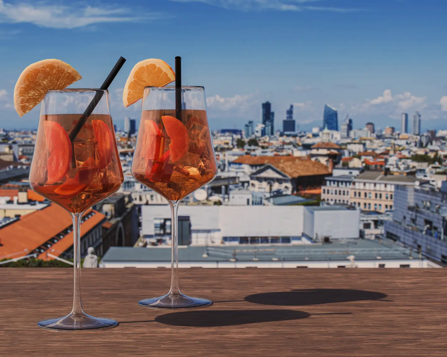 Two Spritz cocktails on a table with view of Milan, Italy
