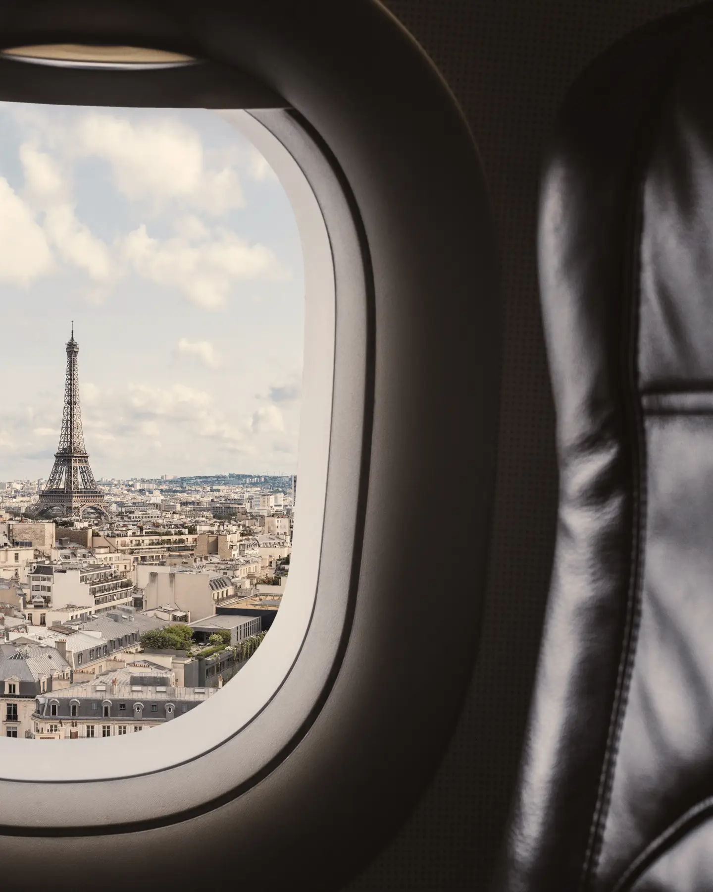 Traveling Paris, France famous landmark and travel destination in Europe. Aerial view Eiffel Tower through airplane window