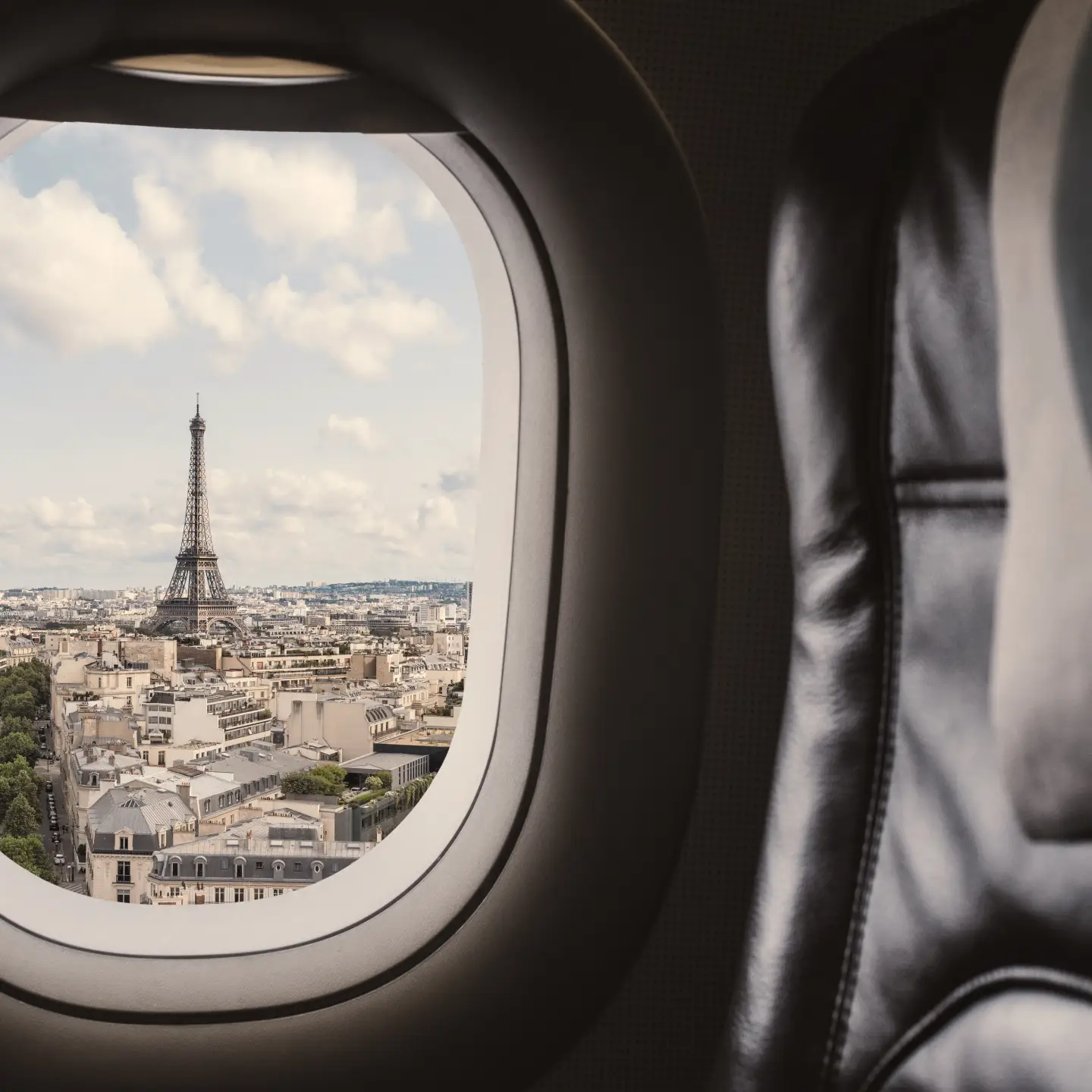 Traveling Paris, France famous landmark and travel destination in Europe. Aerial view Eiffel Tower through airplane window