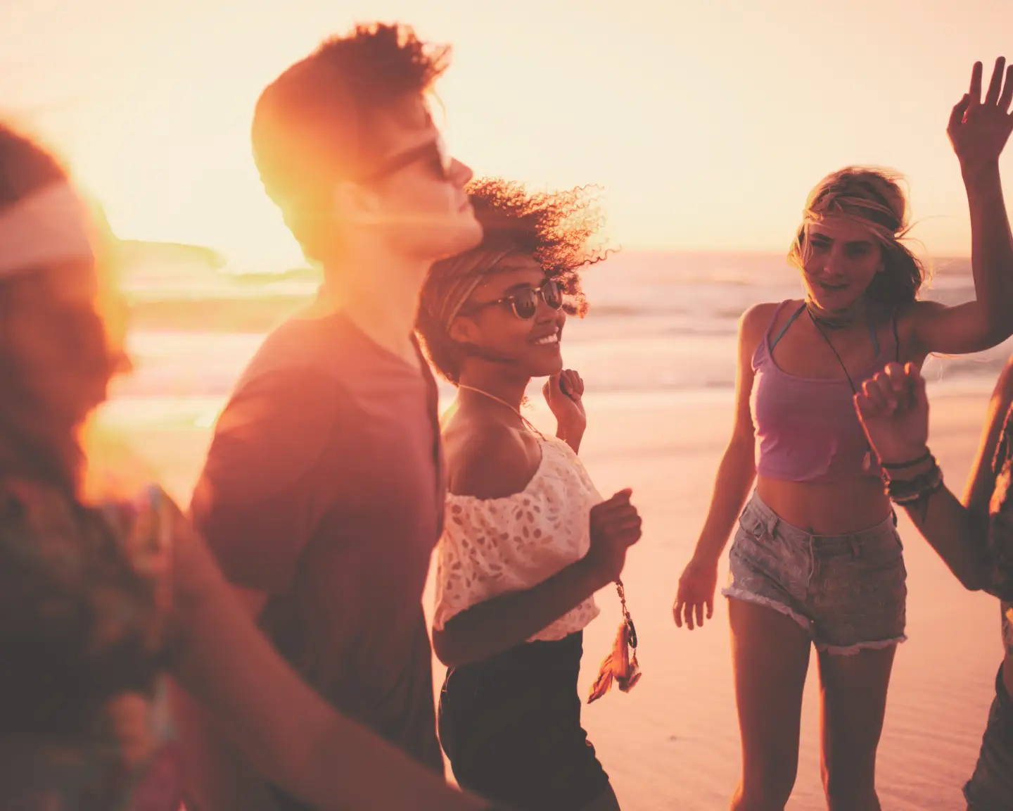 Des amis profitent du coucher de soleil sur la plage