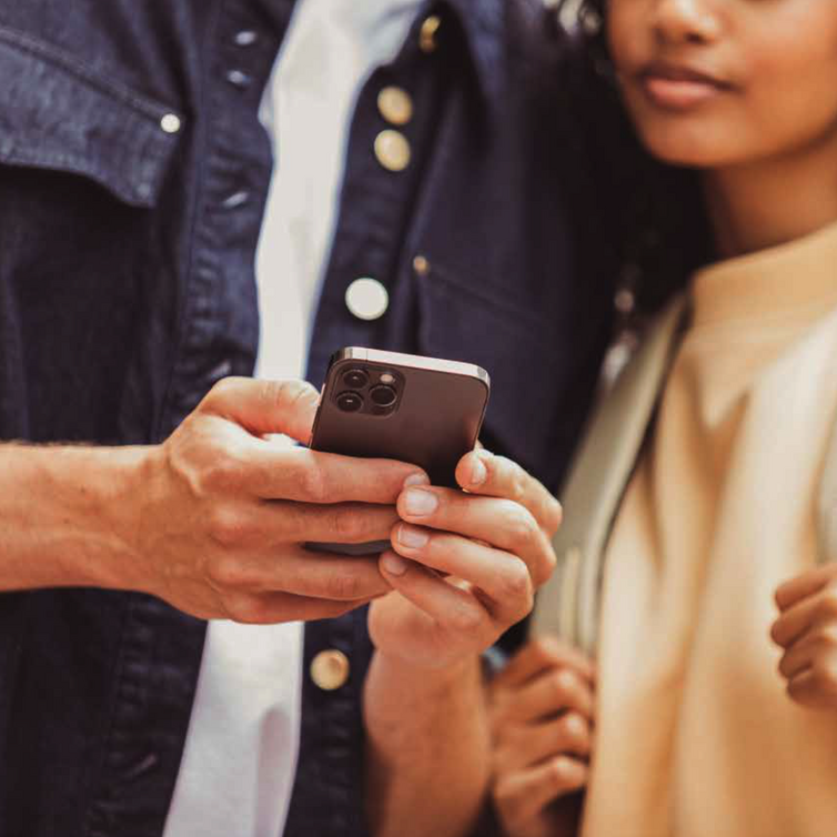 A woman and one man looking at a mobile device