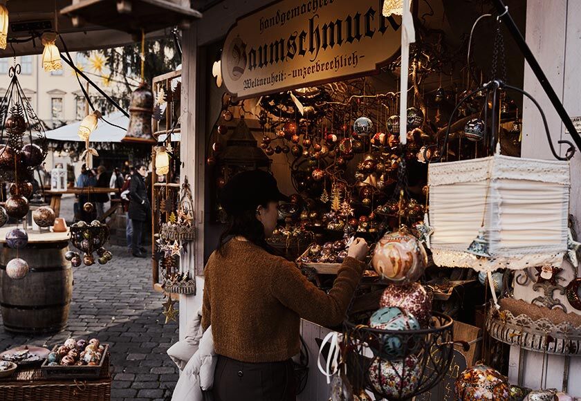 Woman looking at the decorations on a stall at the Dresden Christmas Market.