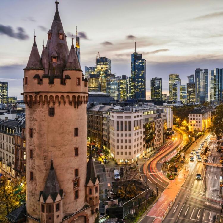 Eschenheim Tower, old and new Frankfurt city buildings with light rail after sunset,