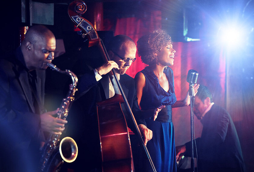 The picture shows the singer and the musicians at a jazz concert