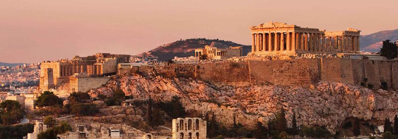 Panoramic view of the Acropolis, overlooking Athens, bathed in soft golden light.