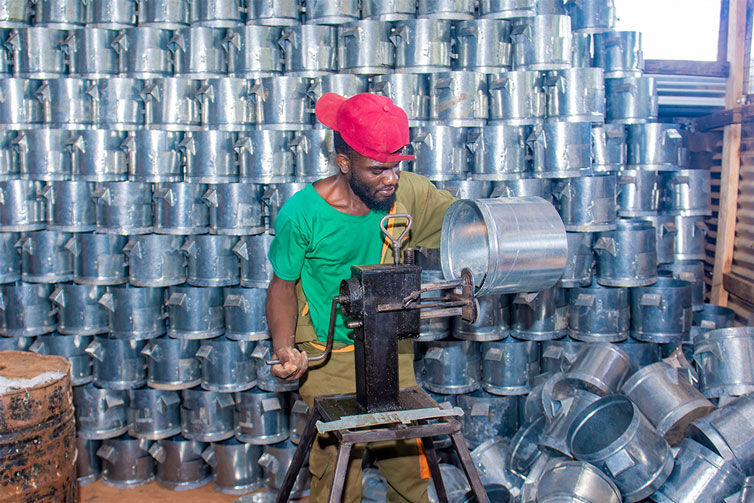 A man makes a cooker in a workshop