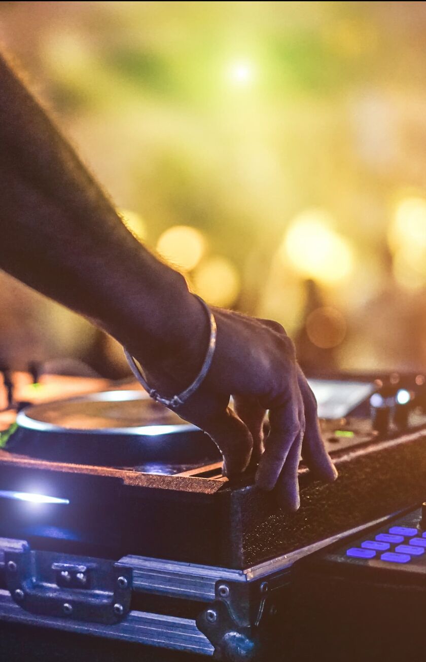 DJ at the turntables, in the background you can vaguely see the dancing party people