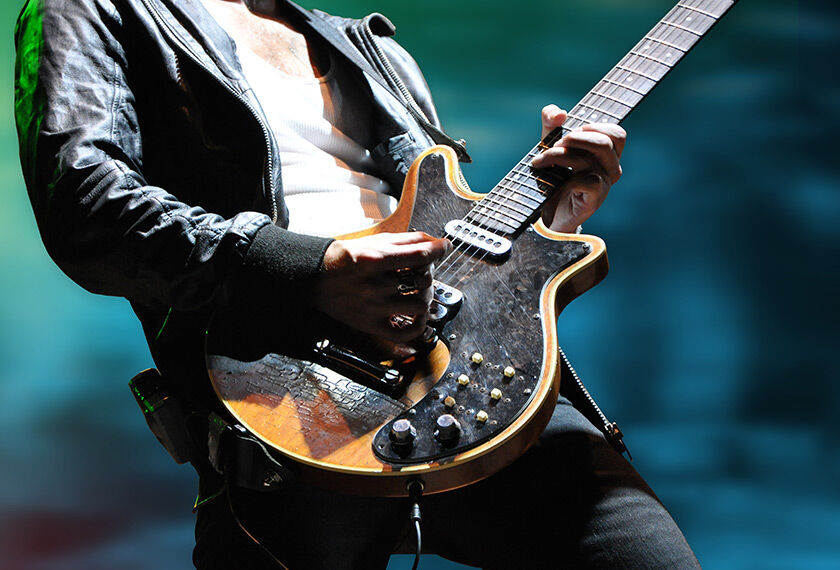 Rock am Ring (FRA) Close-up of hands playing an electric guitar with a blurred green background.