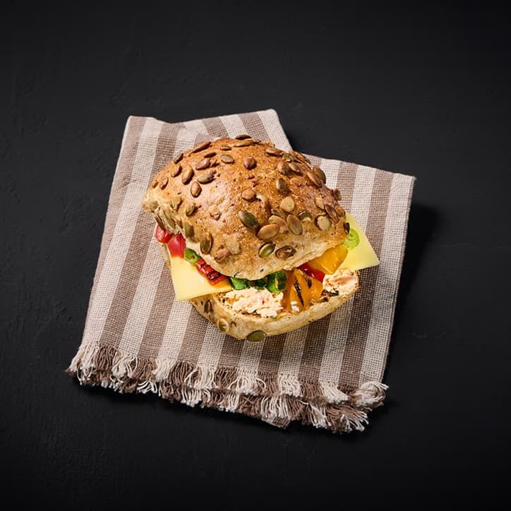Freshly baked multigrain roll with cheese and grilled vegetables
