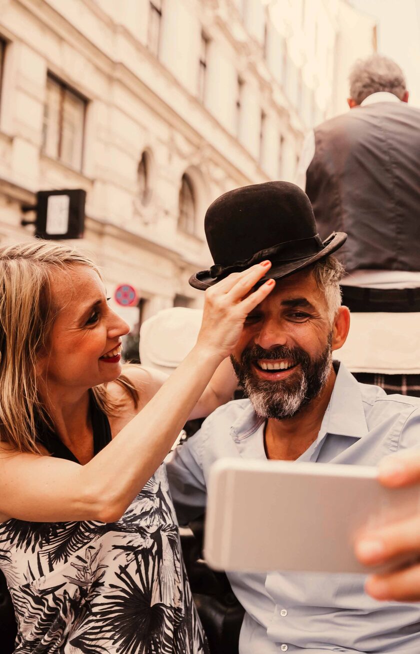 A couple in a historical carriage taking a selfie
