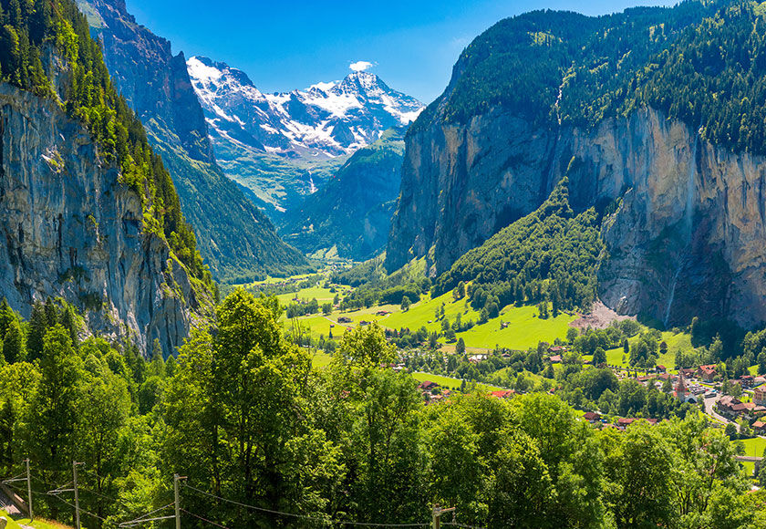 Lauterbrunnen Valley, Switzerland (ZRH) Beautiful view of the Lauterbrunnen valley in Switzerland, with a small village and the green valley, and the still snow-covered mountains in the background
