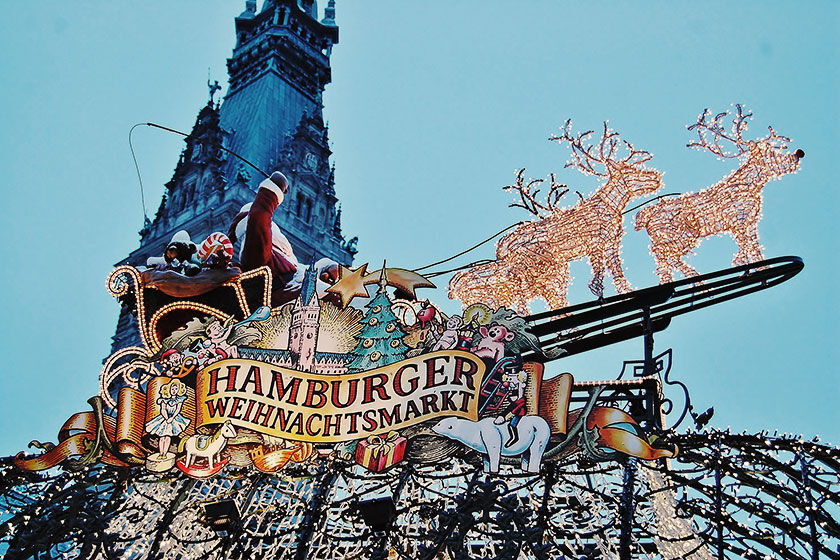 View of the reindeer-drawn Santa Claus float made of Christmas lights with a sign advertising the Hamburg Christmas Market