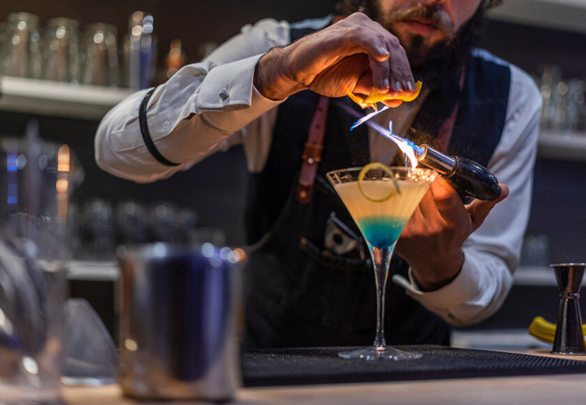 A bartender preparing a trendy cocktail in a European bar