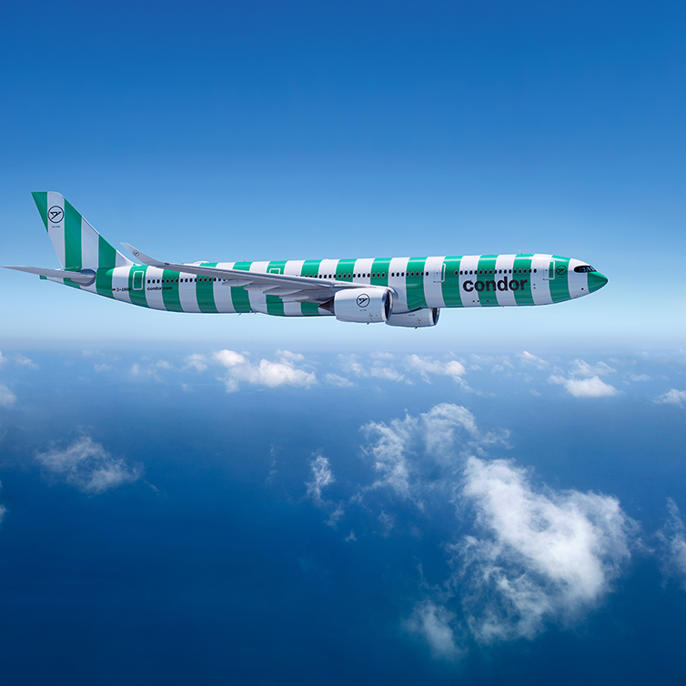 A flying A330 neo aircraft with green and white stripes and Condor branding, blue sky in the background.