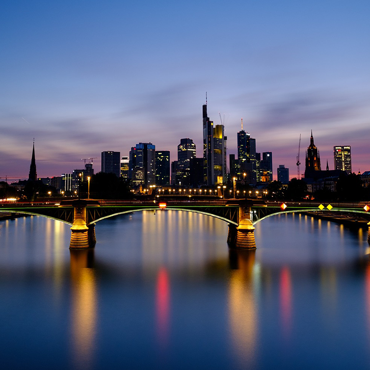 Typical evening image of the illuminated Frankfurt skyline with the Main river in the foreground